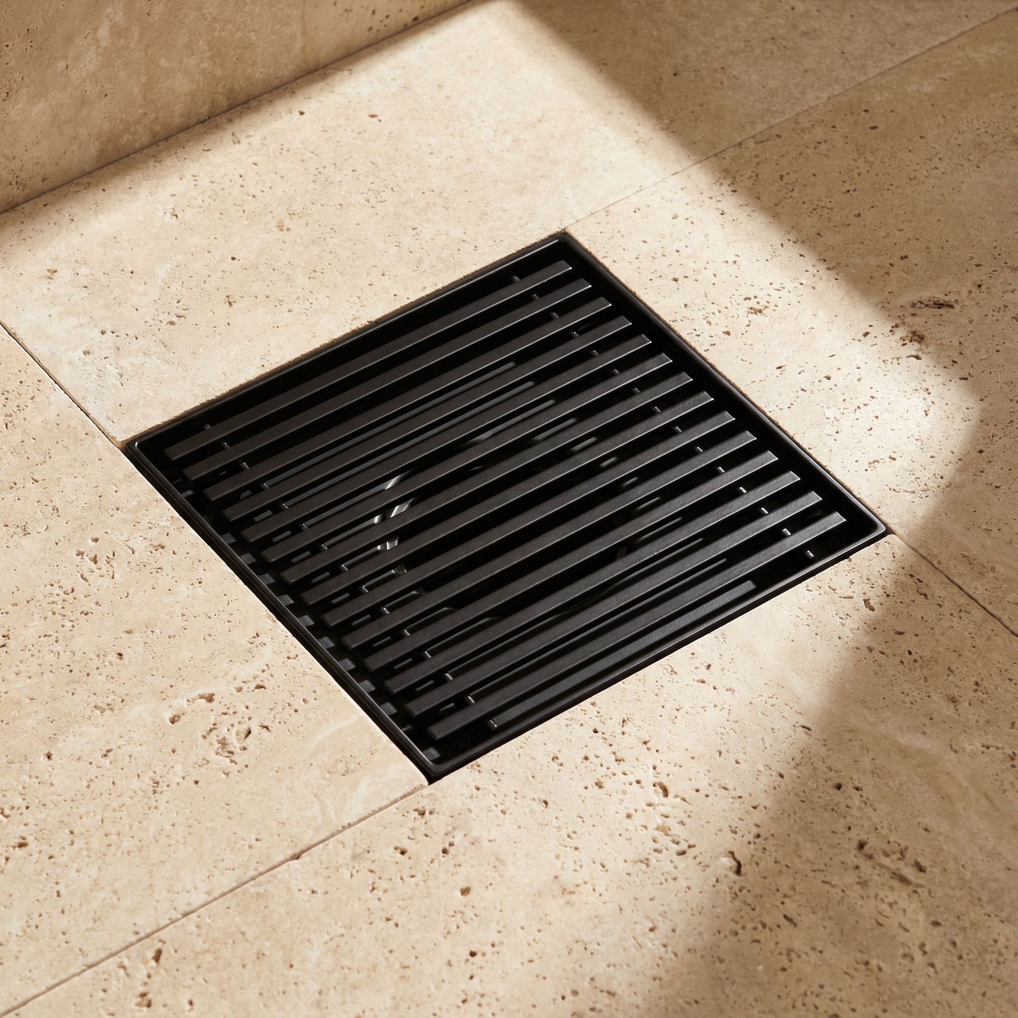 Square stainless steel floor drain with linear grate, laser-welded frame construction and powder-coated surface finish