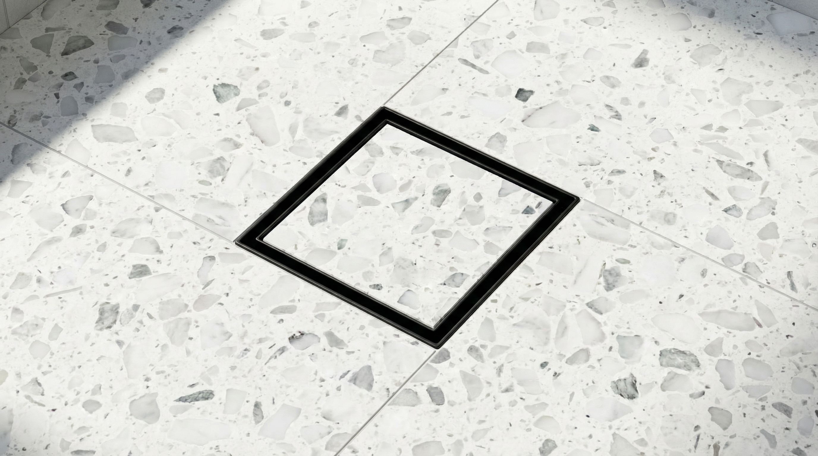Tile-in square stainless steel floor drain with recessed frame, designed for precise alignment with terrazzo flooring