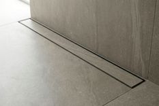 Recessed linear stainless steel shower drain with tile-in cover, engineered for large-format tile flooring systems