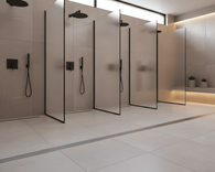 Linear stainless steel floor drain system used in commercial shower area, seamless integration with tiled flooring and partitioned wet zones